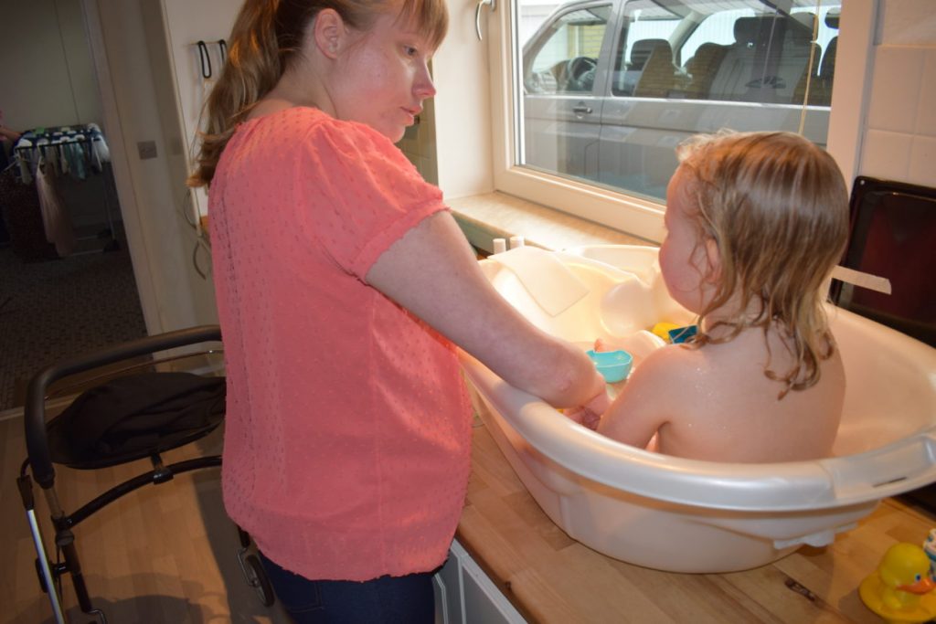 Billede af mor, der bader sit barn på køkkenbordet